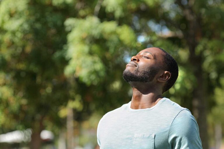 Micro-routines and loving yourself, black man taking a deep breath in nature