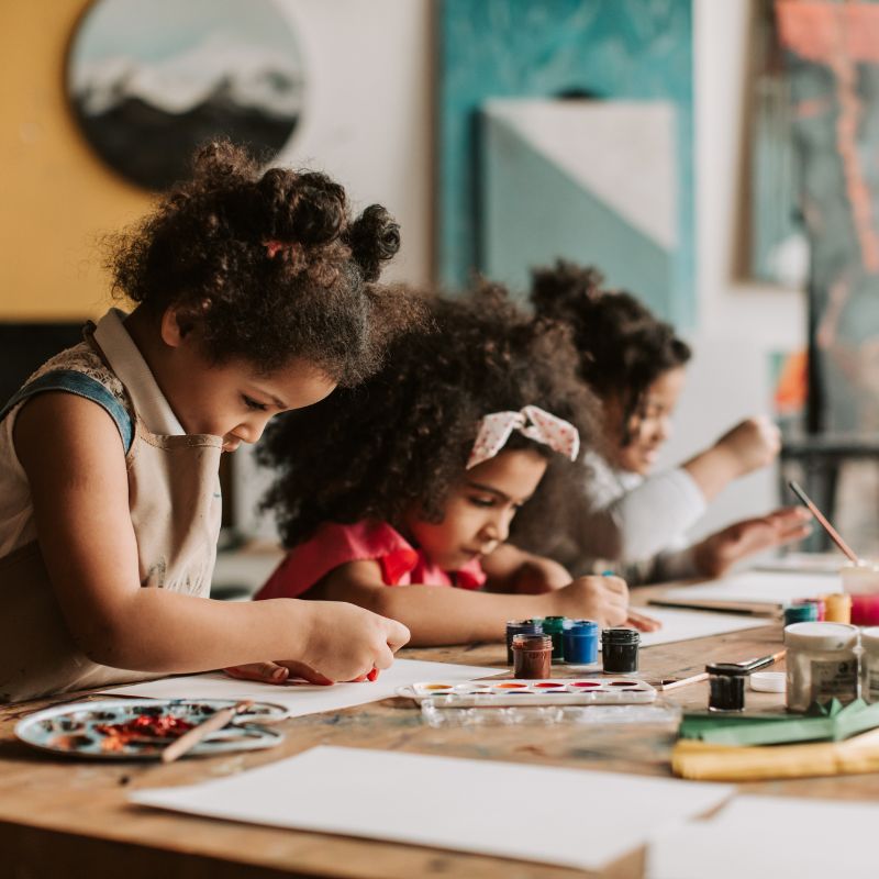 Young children painting in a classroom setting